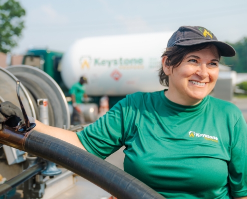 Keystone Propane technician smiling while gathering hose from tanker. (custom photography)