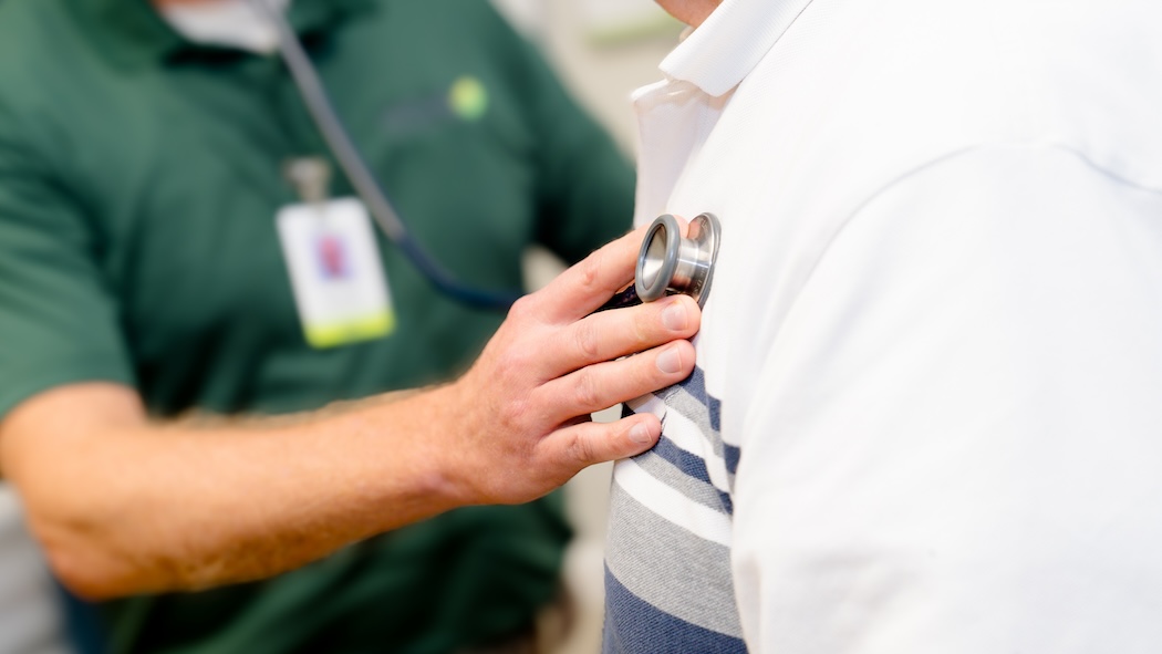 Close up of healthcare provider using a stethoscope to listen to a patient's lungs.