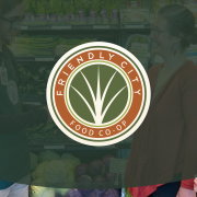 Friendly City Food Co-Op logo on top of green transparency and image in grocery aisle