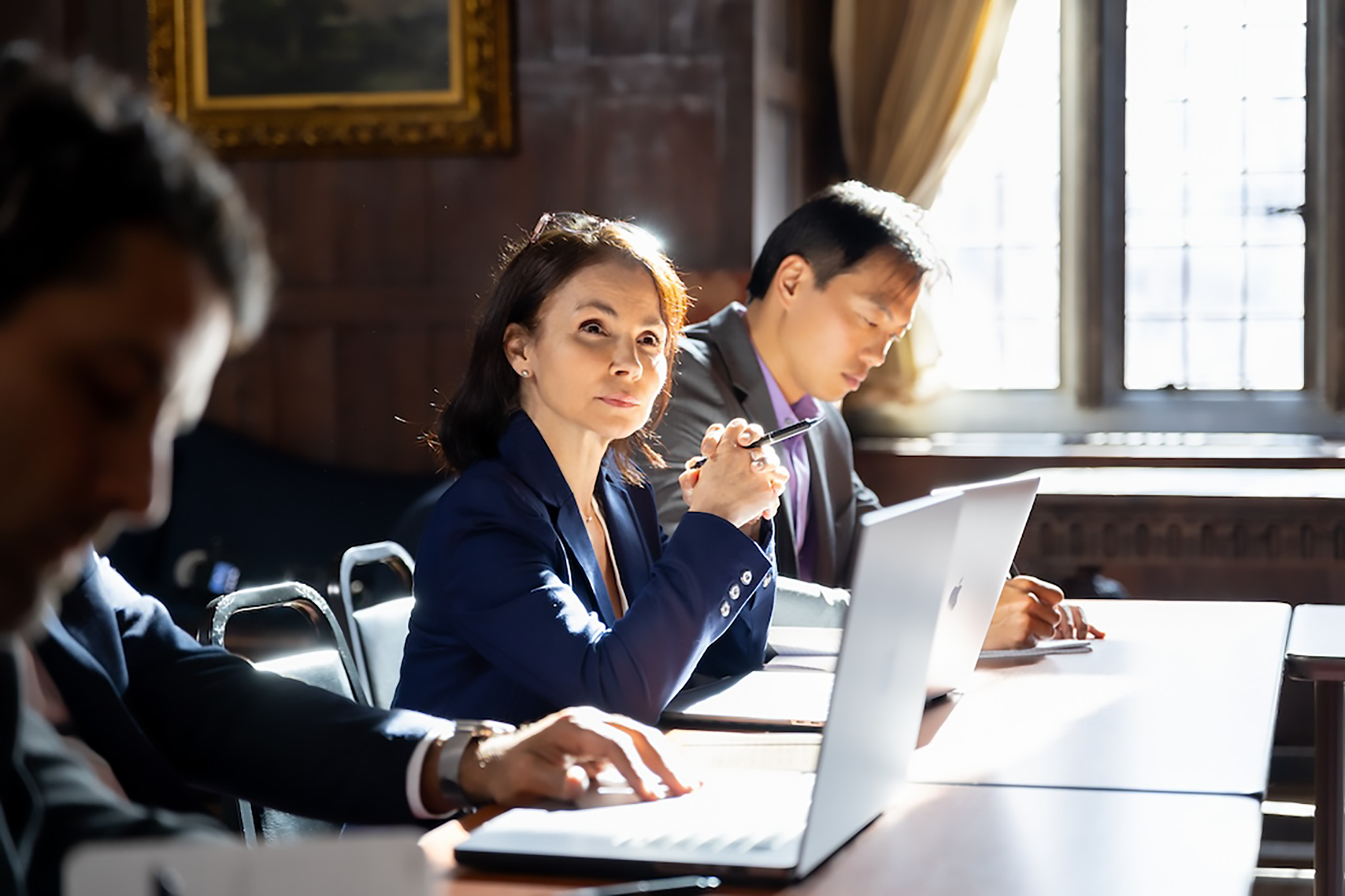 Woman seated in front of laptop looking to the front of the room while training course is in session at FELTG.